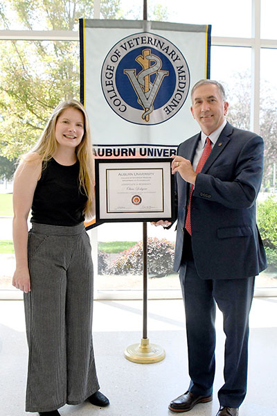 Dean Calvin Johnson presents Dr. Olivia Lockyear with a residency completion certificate